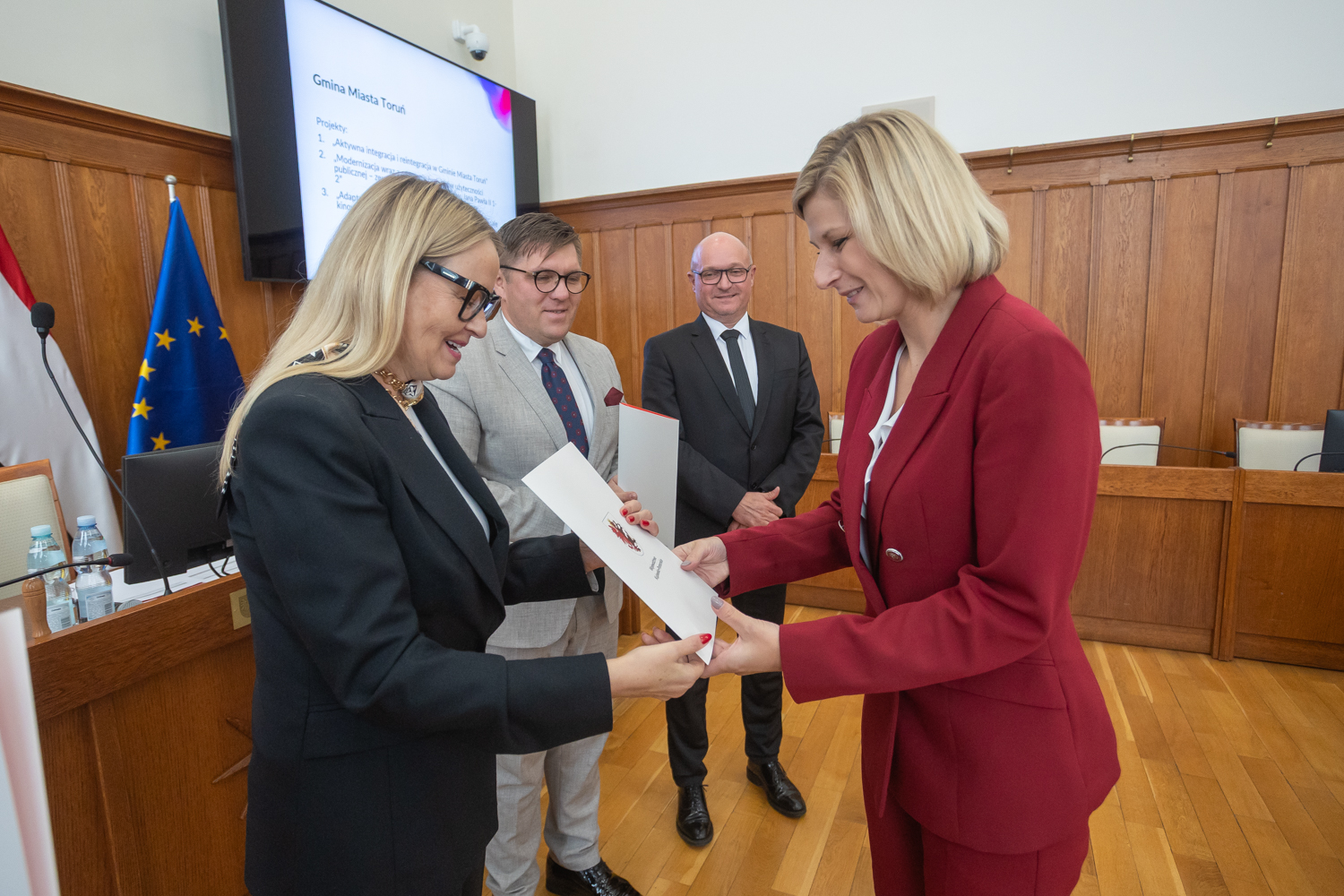 Wicemarszałek województwa Aneta Jędrzejewska wręcza umowy na unijne dofinansowanie zastępcy prezydenta Torunia Dagmarze Zielińskiej 