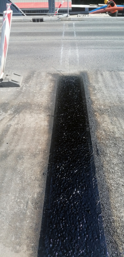 dylatacja z czarnej masy w szczelinie asfaltu na moście