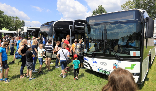 Na pierwszym planie ludzi ogladajacy autobus Solaris, w głebi inne modele