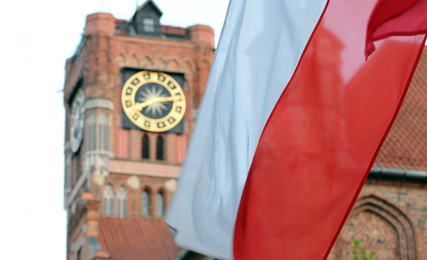 Biało-czerwona flaga, w tle wieża Ratusza Staromiejskiego