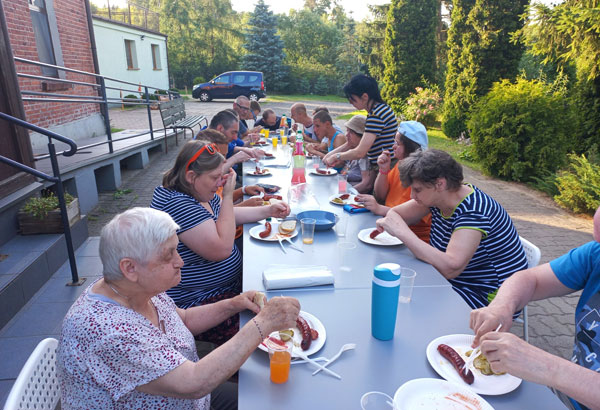Osoby niepełnosprawne przy wspólnym posiłku w plenerze 