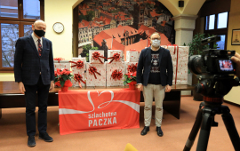 Prezydent Michał Zaleski i jego zastępca Paweł Gulewski stoją przy prezentach, z przodu kamera