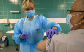 Pielęgniarka aplikuje szczepionkę w ramię pacjenta