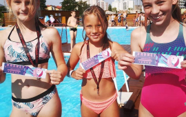 Na zdjęciu dziewczynki pokazują medale zdobyte podczas konkursów przeprowadzonych na basenach lepnich Na Skarpie
