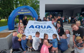 dzieci przed basenem z banerem Aqua Toruń
