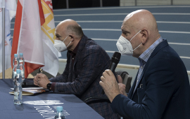 Prezydent Michał Zaleski i dyrektor generalny HME Krzysztof Wolsztyński siedzą za stołem w Arenie Toruń podczas konferencji prasowej - głos zabiera prezydent, w ręku trzyma mikrofon