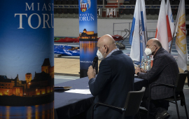 Prezydent Michał Zaleski i dyrektor generalny HME Krzysztof Wolsztyński siedzą za stołem w Arenie Toruń podczas konferencji prasowej