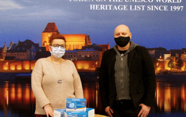 Na zdjęciu dyrektor Wydziału Promocji i Turystyki Ewa Banaszczuk-Kisiel oraz Arkadiusz Liczkowski z przekazanymi maseczkami