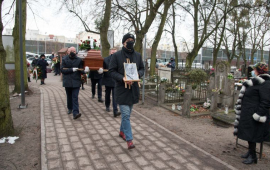 Na zdjęciu obsługa pogrzebu niesie trumnę na cmentarzu przy ul. Wybickiego