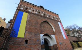 Nazdjęciu: Brama klasztorna, na której powieszone są flagi Polski i Ukrainy