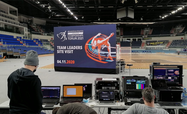 W hali Arena Toruń ustawiony jest duży ekran, na którym wyświetlkane są prezentacje o Toruniu i hali, na pierwszym planie stół techniczny, skąd całość jest transmitowana do uczestników spotkania