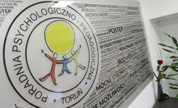 Na zdjęciu tablica z logo Poradni Psychologiczno-Pedagogicznej w Toruniu