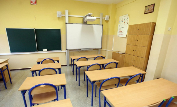 Na zdjęciu widać pustą salę lekcyjną - ławki i tablicę.