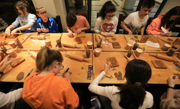 Na zdjęciu: młodzież siedzi przy stole podczas warsztatów piernikarskich
