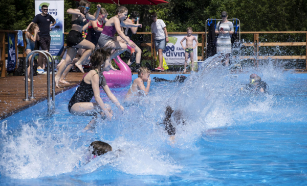 Na zdjęciu: dzieci wskakują do basenu, woda rozpryskuje się wokół