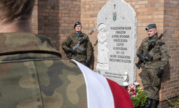 Dwóch żołnierzy pełni wartę przy tablicy Matki Polki Sybiraczki
