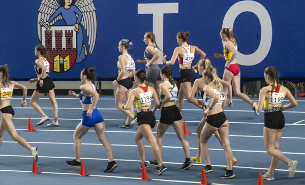 Na zdjęciu widać biegnące po bieżni  młode zawodniczki w hali Arena Toruń