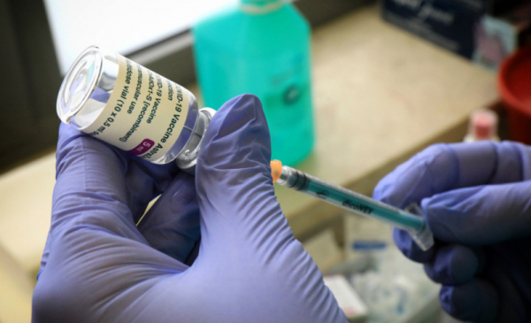Na zdjęciu osoba w rękawiczkach ochronnych trzyma strzykawkę ze szczepionką