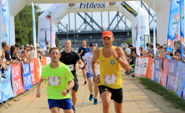 Na zdjęciu: biegną uczestnicy Run Toruń, w tle most drogowy