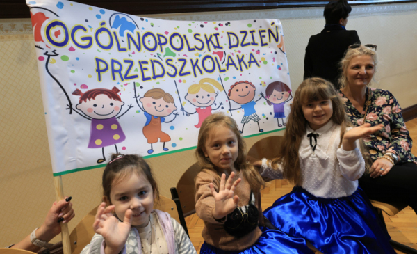 Na zdjęciu: dzieci machają na tle transparentu z napisem Ogólnopolski Dzień Przedszkolaka