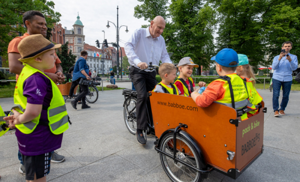 Na zdjęciu prezydent Torunia Michał Zaleski wiezie rowerem cargo przedszkolaków z PM nr 7