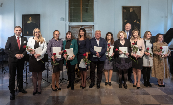 Na zdjęciu: prezydent Michał Zaleski stori z nauczycielami, którzy trzymają teczki z listami gratulacyjnymi