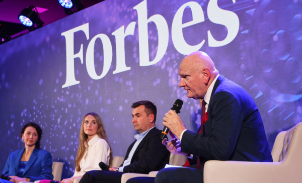 Na zdjęciu: prezydent Michał Zaleski siedzi wśród panelistów na scenie, w tle napis "Forbes"