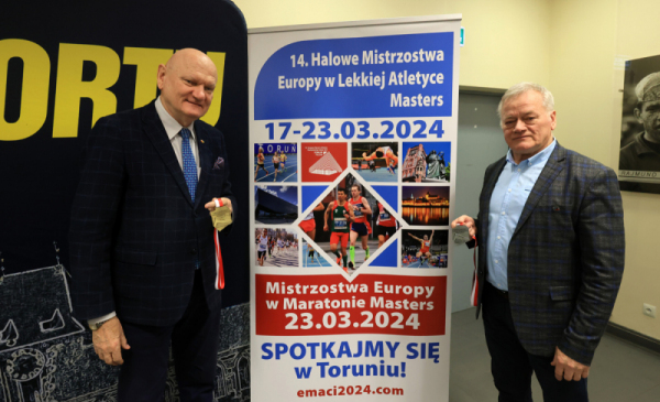 Na zdjęciu: prezydent Michał Zaleski i Wacław Krankowski trzymają w rękach medale i stoją przy banerze zapowiadającym Halowe Mistrzostwa Europy w Lekkiej Atletyce Masters