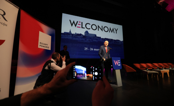 Na zdjęciu:prezydent Michał Zaleski przemawia na scenie, za nim duży napis Welconomy Toruń