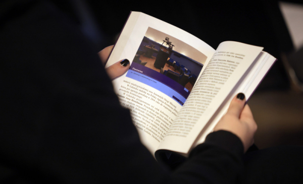 Na zdjęciu: otwarty "Przewodnik astronomiczny po Polsce", widac dłonie trzymające tę otwartą książkę