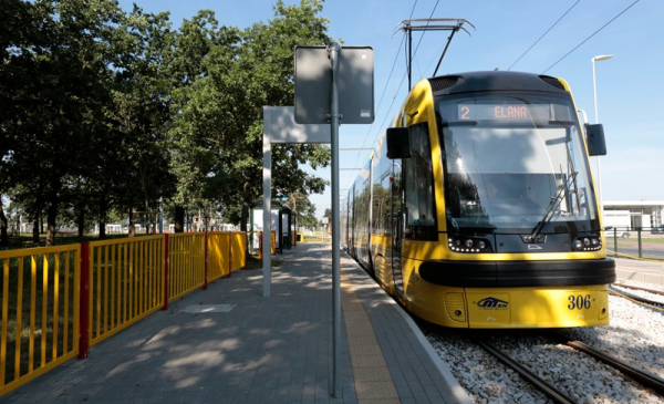 Na zdjęciu: żółto-niebieski tramwaj stoi na przystanku