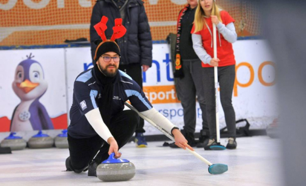 Na zdjęciu: zawodnicy gry w curling na lodowisku w świątecznych strojach