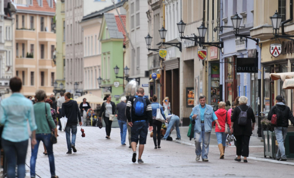 Na zdjęciu widać ludzi idących ulicą Szeroką