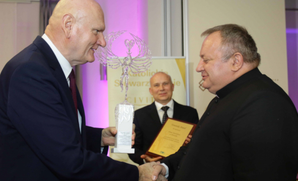 Prezydent Michał Zaleski wręcza statuetkę anioła ks. Waldemarowi Cisło