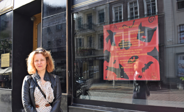 Na zdjęciu: Malina Barcikowska przy witrynie Żabki, w której wyeksponowane są wiersz Wisławy Szymborskiej
