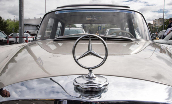 Na zdjęciu: fragment maski samochodu ze znaczkiem Mercedesa