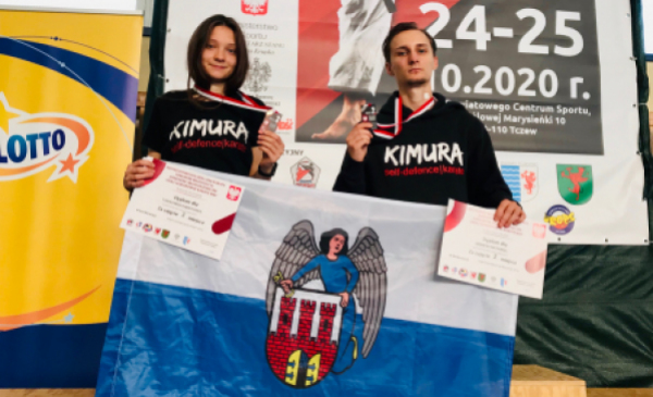 Na zdjęciu: Wiktoria Tarnowska i Nataniel Gębicki z medalami i toruńską flagą
