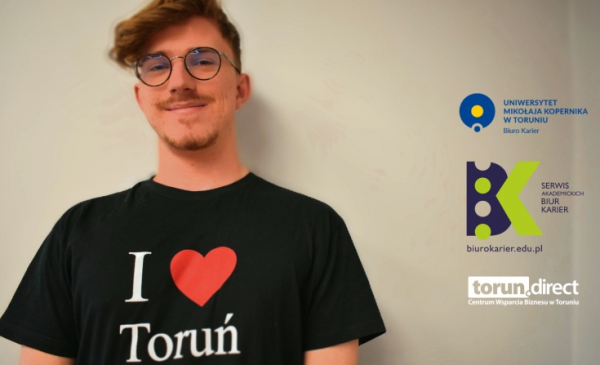 Uśmiechnięty chłopak w czarnej koszulce z napisem I love Toruń i logotypami