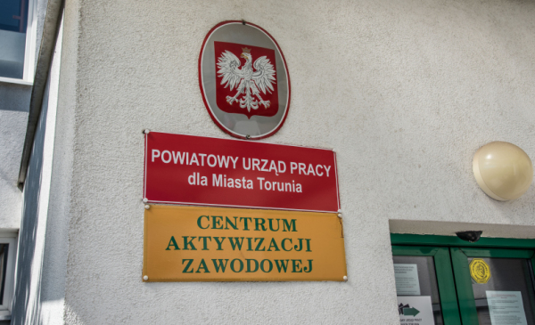 Na zdjęciu widać tabliczki z napisem "Powiatowy Urząd Pracy dla Miasta Torunia" oraz "Centrum Aktywizacji Zawodowej"