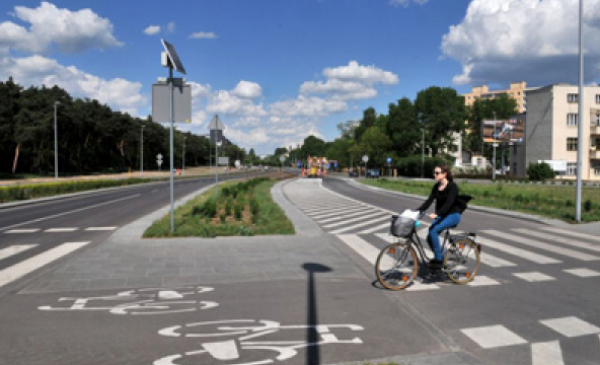 Na zdjęciu kobieta przjeżdzająca przez nowo ścieżkę rowerową przy ul. Bema