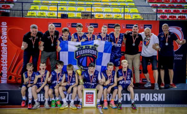 Na zdjęciu drużyna Twardych Pierników Toruń U13 wraz z trenerami pokazuje medale