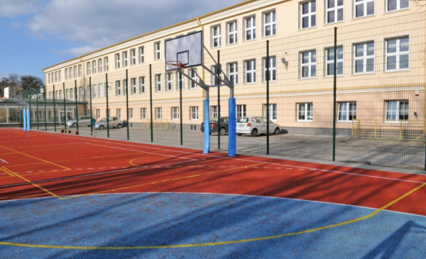 Na zdjęciu: budynek Zaspołu Szkół Technicznych, przed nim boisko typu orlik i kosz do gry w piłkę koszykową