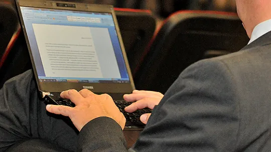 osoba pisząca na laptopie
