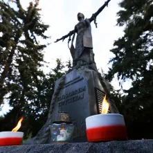 Kwiaty pod pomnikiem ks. Popiełuszki i tablicą Solidarności