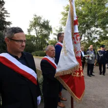 Kwiaty pod pomnikiem ks. Popiełuszki i tablicą Solidarności