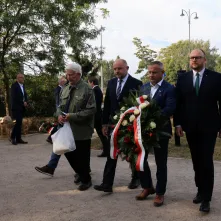 Kwiaty pod pomnikiem ks. Popiełuszki i tablicą Solidarności