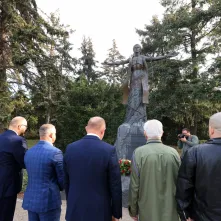 Kwiaty pod pomnikiem ks. Popiełuszki i tablicą Solidarności