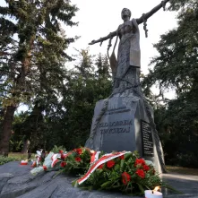 Kwiaty pod pomnikiem ks. Popiełuszki i tablicą Solidarności