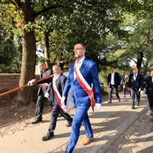 Kwiaty pod pomnikiem ks. Popiełuszki i tablicą Solidarności