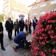 Kwiaty pod pomnikiem ks. Popiełuszki i tablicą Solidarności